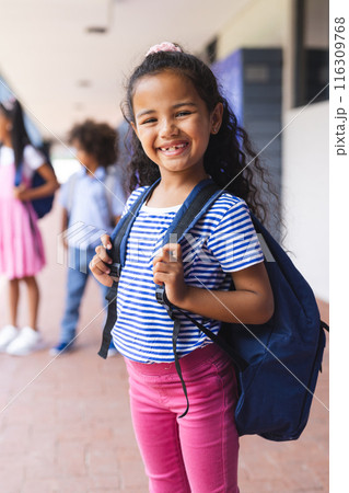Biracial girl smiling with backpack, ready for school 116309768