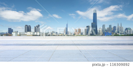 Empty square floor is providing space for product placement with modern city skyline in the background Empty square floor is providing space for product placement with modern city skyline in the background 116309892