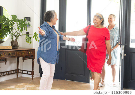 Diverse group of senior women greeting each other with open arms and smiles Diverse group of senior women greeting each other with open arms and smiles 116309999