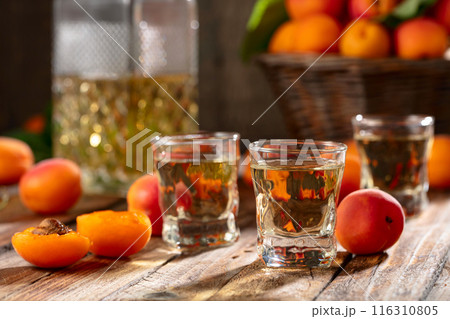 Apricot liqueur or grappa and fresh apricots. 116310805