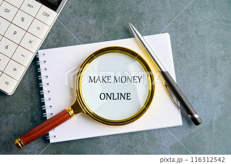 Make Money Online symbol. Concept words Make Money Online through a magnifying glass in a notebook on a gray background 116312542