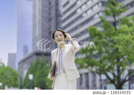 手帳を手に持つオフィス街のビジネスウーマン 116314235