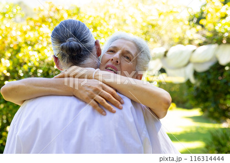 Senior bride hugging groom outdoors, at their wedding 116314444
