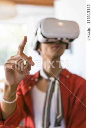 Using VR headset, young man interacting with virtual environment at home 116315186