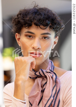 Transgender transgender woman posing confidently with hand on chin, wearing stylish scarf 116315322