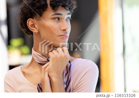 Transgender transgender woman adjusting scarf, looking away, feeling confident at home 116315326