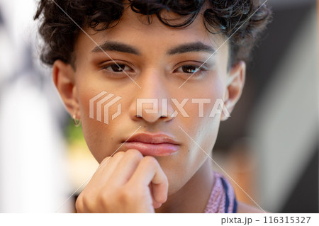 Close-up of thoughtful transgender transgender woman resting chin on hand, looking pensive 116315327