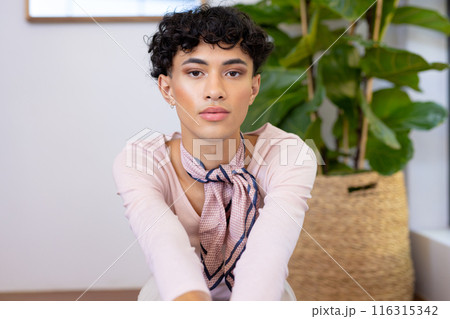 Sitting indoors, transgender transgender woman posing confidently with plant in background 116315342