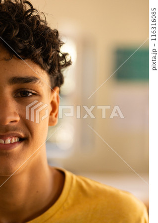 Smiling teenage boy in high school, wearing yellow shirt, looking at camera, copy space 116316085