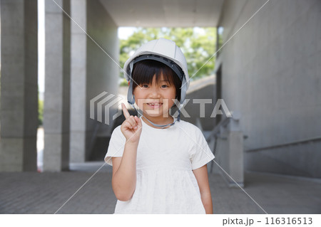 ヘルメットをかぶった笑顔の小学生。指差しする 116316513