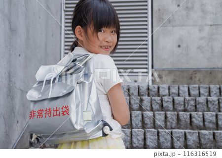 防災用リュックサック、非常持出袋を背負う小学生の女の子 防災用リュックサック、非常持出袋を背負う小学生の女の子 116316519