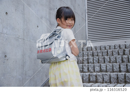 防災用リュックサック、非常持出袋を背負う小学生の女の子 防災用リュックサック、非常持出袋を背負う小学生の女の子 116316520