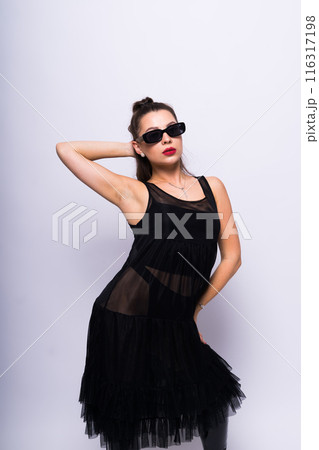 Young brunette lady in black dress posing on grey background 116317198