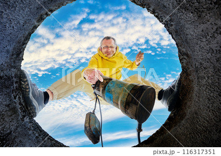 Man immerses sewage pump in septic tank to pumping wastewater to sewage drain before cleaning, bottom view. Man immerses sewage pump in septic tank to pumping wastewater to sewage drain before cleaning, bottom view. 116317351