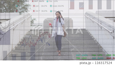 Image of graphs, trading board, biracial woman talking on phone with coffee walking downstairs 116317524