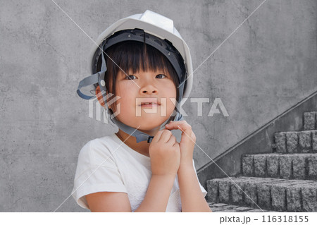 コンクリート建物背景にヘルメットをかぶった小学生の女の子 コンクリート建物背景にヘルメットをかぶった小学生の女の子 116318155
