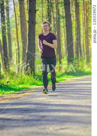 Man jogging in city partk at beautiful summer day. Sport fitness model caucasian ethnicity training outdoor. Man jogging in city partk at beautiful summer day. Sport fitness model caucasian ethnicity training outdoor. 116319972
