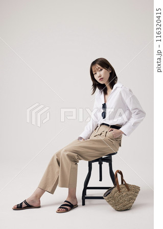 Korean Woman Sitting in Chair in Old Money Style 116320415