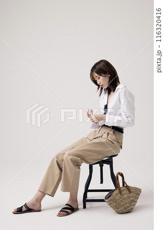 Korean Woman Sitting in Chair in Old Money Style 116320416
