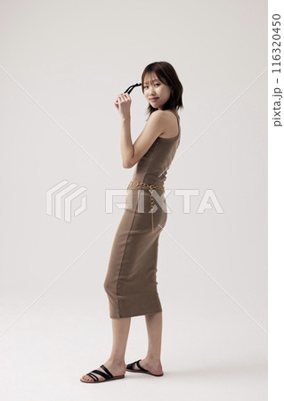 Korean Woman Wearing a Knit Dress and Holding a Sundlas Korean Woman Wearing a Knit Dress and Holding a Sundlas 116320450