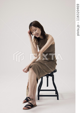 A Korean Woman Sitting in a Chair, Close Her Eyes, Laugh 116320469