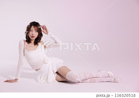 A Korean woman in her 20s who poses on the floor wearing a white ballet core look with a light pink background A Korean woman in her 20s who poses on the floor wearing a white ballet core look with a light pink background 116320518