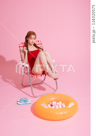 A Korean woman in her 20s sitting in a chair wearing a red monokini look A Korean woman in her 20s sitting in a chair wearing a red monokini look 116320575