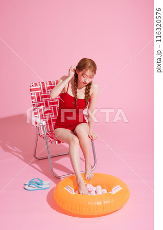 A Korean woman in her 20s who wears a monokini look and puts her feet in a tube A Korean woman in her 20s who wears a monokini look and puts her feet in a tube 116320576