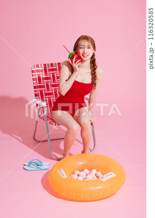 A Korean woman in her 20s who sits on a chair wearing a monokini look and drinks A Korean woman in her 20s who sits on a chair wearing a monokini look and drinks 116320585
