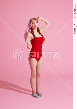 Korean woman in her 20s posing with a dragonfly with a ball in a monokini look 116320674