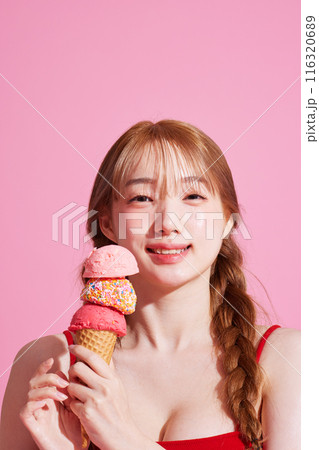 A Korean woman in her 20s holding an ice cream in a pink background A Korean woman in her 20s holding an ice cream in a pink background 116320689
