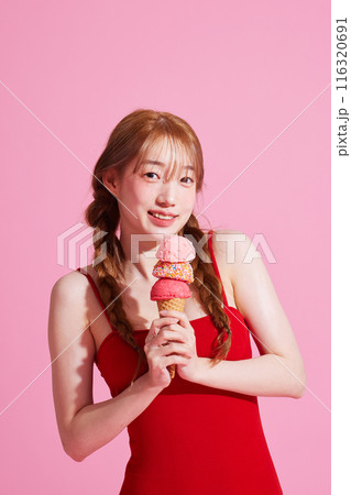 A Korean woman in her 20s holding an ice cream in a pink background 116320691
