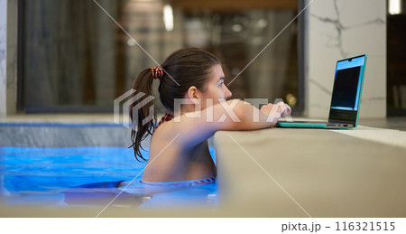 Woman Working on Laptop from Swimming Pool 116321515