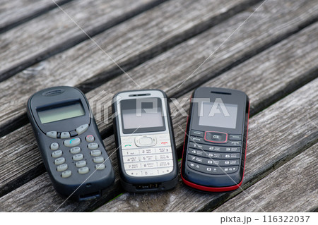 Old cell phones on wooden table 116322037