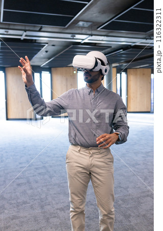 Using VR headset, man interacting with virtual environment in modern office Using VR headset, man interacting with virtual environment in modern office 116322311