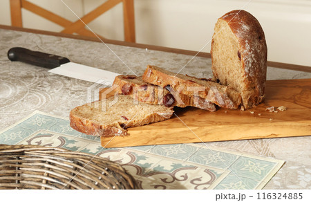 Homemade sliced rye bread with cranberries on wooden board. Kitchen interior. Food and health. Homemade sliced rye bread with cranberries on wooden board. Kitchen interior. Food and health. 116324885