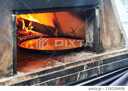 Socca being prepared in the oven in Nice, the French Riviera. Socca is a specialty of southeastern French cuisine. a pancake made from chickpea flour. Socca being prepared in the oven in Nice, the French Riviera. Socca is a specialty of southeastern French cuisine. a pancake made from chickpea flour. 116326406