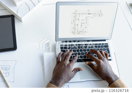 Man architect working with software on laptop using technical drafts drawings at office workplace Man architect working with software on laptop using technical drafts drawings at office workplace 116326716