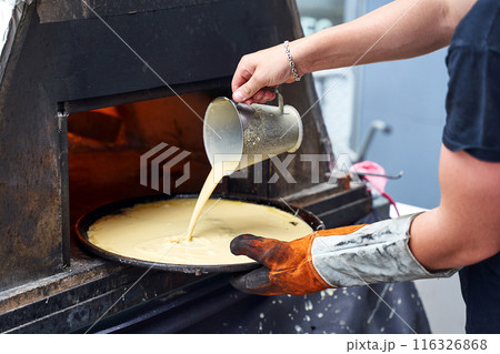 Socca being prepared in the oven in Nice, the French Riviera. Socca is a specialty of southeastern French cuisine. a pancake made from chickpea flour. Socca being prepared in the oven in Nice, the French Riviera. Socca is a specialty of southeastern French cuisine. a pancake made from chickpea flour. 116326868