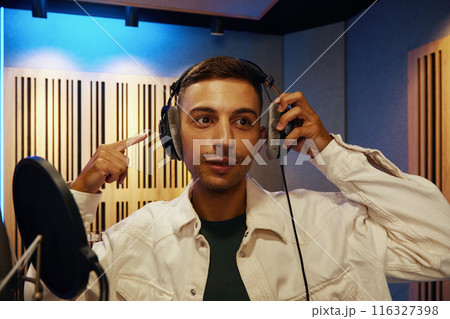Young Man Recording Song In Studio Young Man Recording Song In Studio 116327398