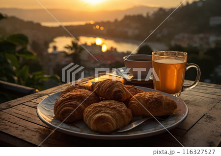 cup of coffee and french croissant on table, balcony with view of beautiful landscape, still life, sea and mountains, resort town, sunset cup of coffee and french croissant on table, balcony with view of beautiful landscape, still life, sea and mountains, resort town, sunset 116327527