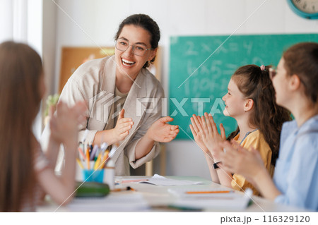 Happy kids and teacher at school Happy kids and teacher at school 116329120