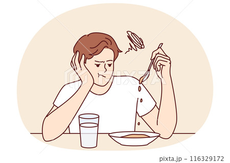 Man suffers from lack of appetite sitting at table in kitchen and does not want to eat breakfast 116329172