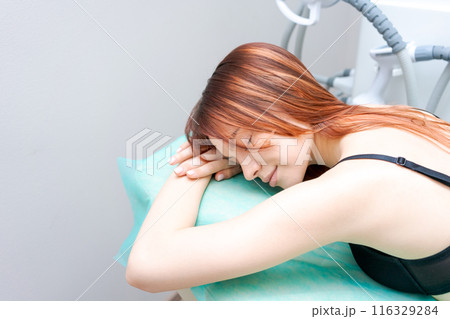 A woman is sleeping on a bed with a green sheet A woman is sleeping on a bed with a green sheet 116329284