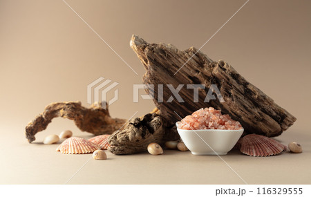 Pink himalayan salt with snags and seashells on a beige background. Pink himalayan salt with snags and seashells on a beige background. 116329555