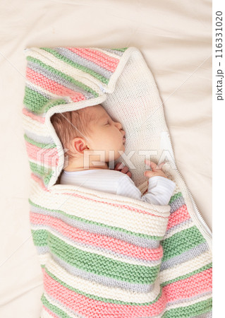 Newborn Baby Asleep in Colorful Knitted Blanket Newborn Baby Asleep in Colorful Knitted Blanket 116331020
