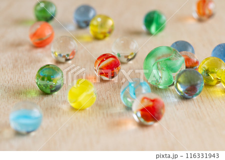 木の板に並べたカラフルなビー玉 116331943