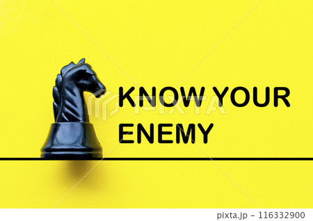 Know your enemy text on yellow cover with black knight chess background. Battle concept Know your enemy text on yellow cover with black knight chess background. Battle concept 116332900