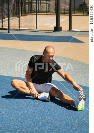 Athlete stretching legs after workout or run in public park. Outdoors training. Morning routine. Summer workout . Athlete stretching legs after workout or run in public park. Outdoors training. Morning routine. Summer workout . 116333430