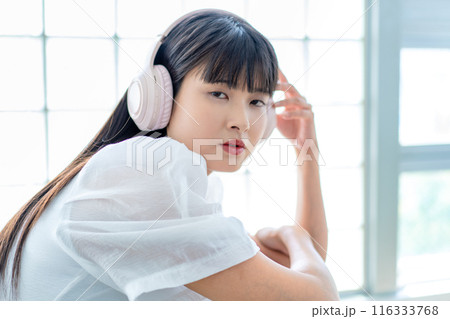 ヘッドホンで音楽を聴く若い女性 116333768